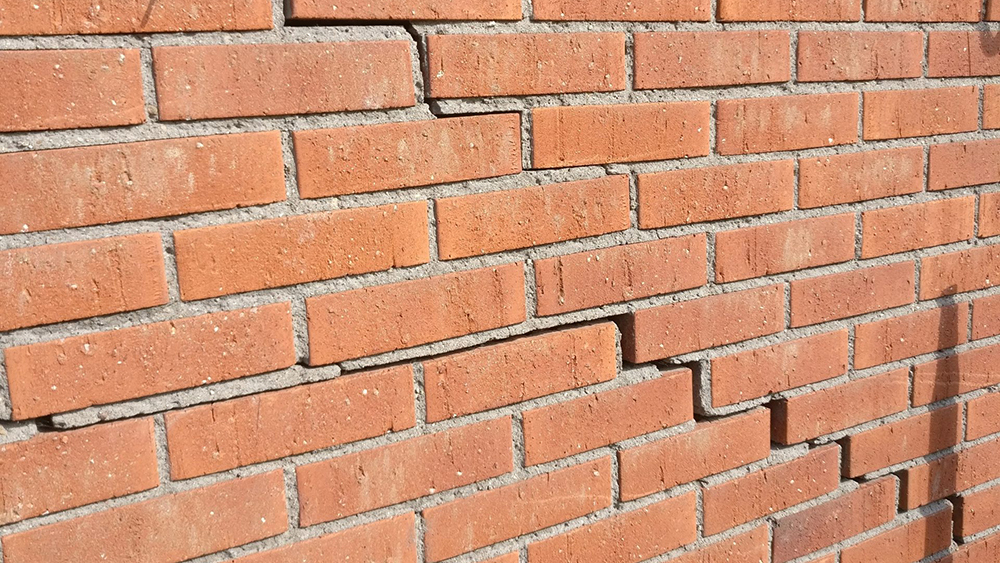 A stair step crack in brickwork on an external residential home wall